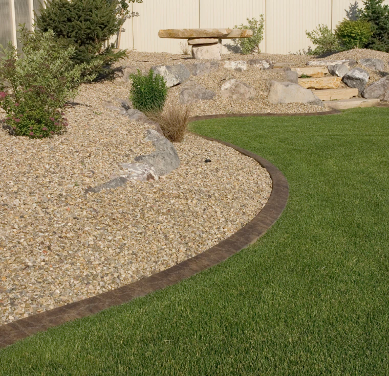 landscape patio with some grass and a path of stones around